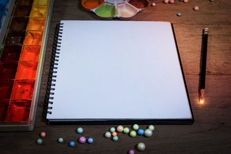 closeup open note book with tray colors on wood backgroundの写真素材