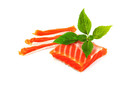 Piece of fresh salmon fillet sliced with leaf basil isolated on white backgroundの写真素材