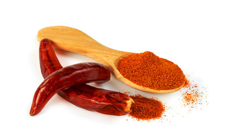 red ground paprika powder or dry chili pepper with wooden spoon isolated on white backgroundの写真素材
