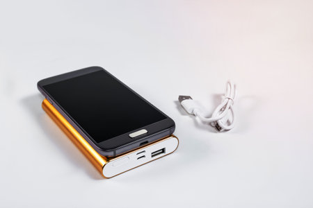 Golden powerbank with smart phone on backgroundの写真素材
