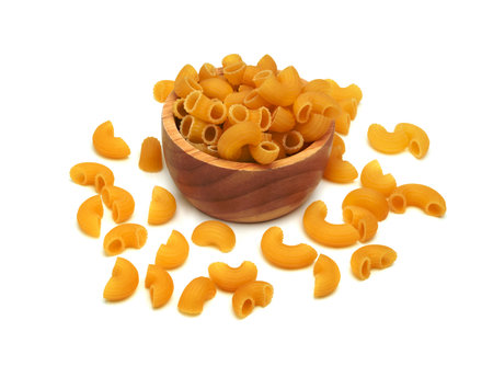 raw macaroni pasta with wooden bowl isolated on white backgroundの写真素材