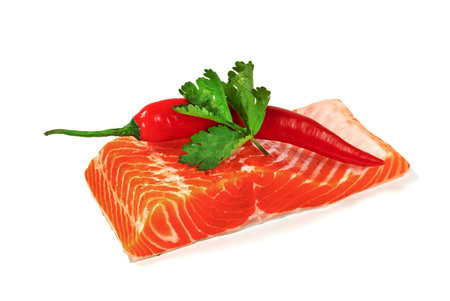 Piece of fresh salmon fillet sliced with coriander leaves and red pepper isolated on white backgroundの写真素材