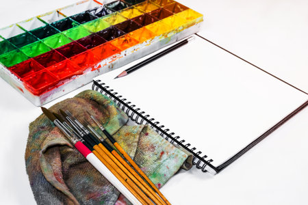 closeup open note book with tray colors on backgroundの写真素材