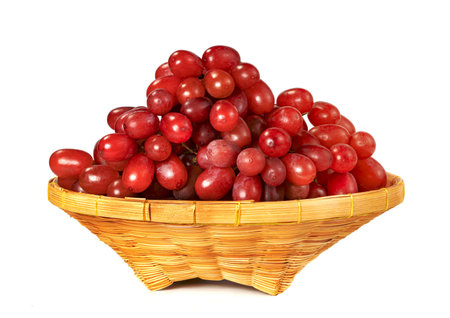 red seedless grapes in the basket isolated on white backgroundの写真素材