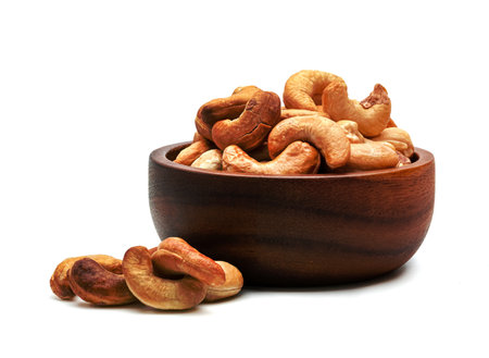 Roasted cashew nuts in wooden bowl isolated on white backgroundの写真素材