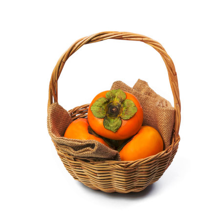 Persimmon in the basket isolated on white backgroundの写真素材