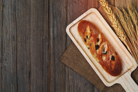 pillow raisin bread and wheat ears and sack on wooden background,top viewの写真素材