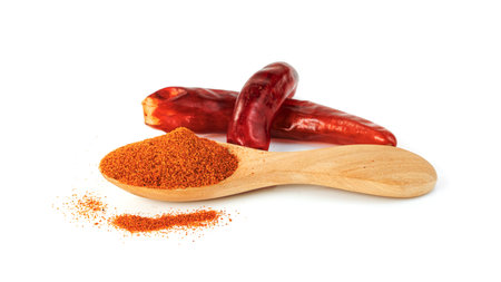 red ground paprika powdered or dry chili pepper with wooden spoon isolated on white backgroundの写真素材