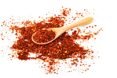 red ground paprika powdered or dry chili pepper with wooden spoon isolated on white backgroundの写真素材