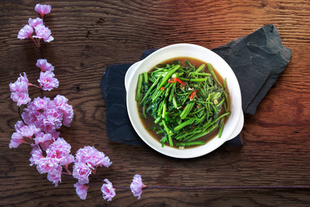 Stir Fried Water Spinach or pak boong fai daeng on white dishの写真素材