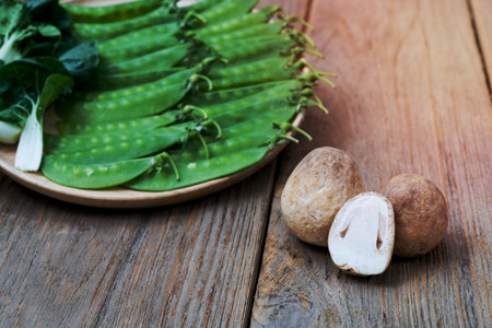 Straw mushroom with peas on wooden dishの写真素材