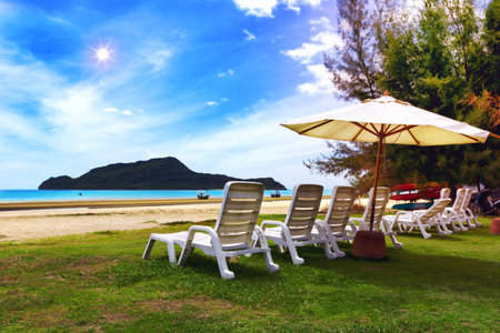 White beach chair and umbrella on tropical beach with blue skyの写真素材