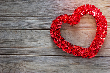 Tinsel heart  decoration on wood backgroundの写真素材