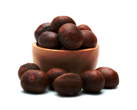 peeled roasted chestnut in wooden bowl isolated on white backgroundの写真素材