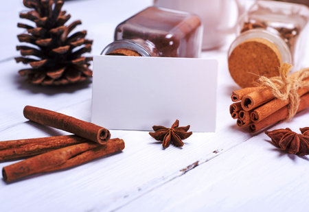 empty white paper tag and cinnamon sticks on a white wooden backgroundの写真素材