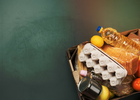 cardboard box with various products, fruits, pasta, sunflower oil in a plastic bottle and preservation. Donation concept, top viewの写真素材