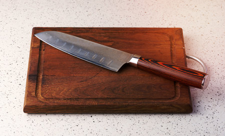 Empty wooden cutting board and kitchen knife on the table, top viewの写真素材