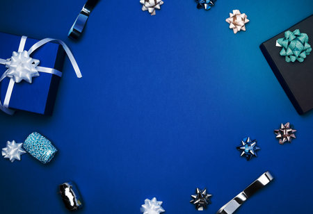 cardboard gift square boxes, bows, ribbons for packaging on a dark blue background, empty space in the middle, trend colorsの写真素材