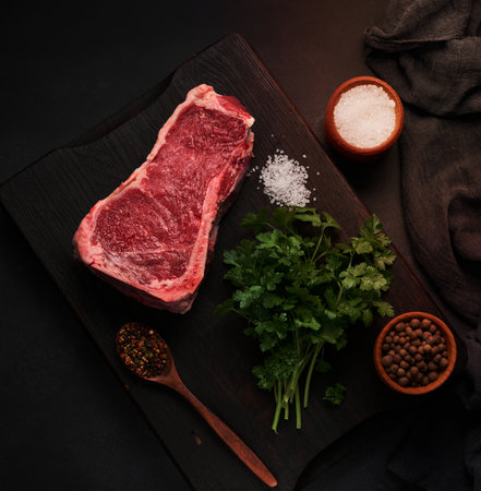 Fresh raw piece of beef meat, striploin steak on a black background, top view. Marbled piece of meatの写真素材