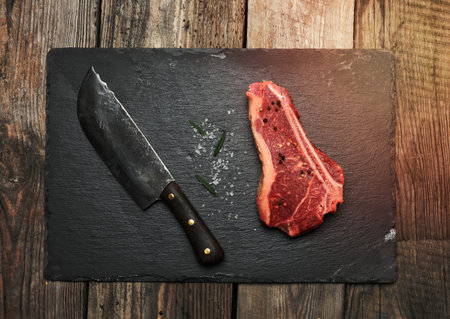 fresh raw piece of beef meat, striploin steak on a wooden background, top view. Marbled piece of meat New Yorkの写真素材