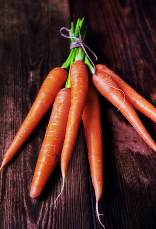 Fresh carrots on a brown wooden background, close upの写真素材