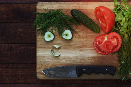 Ingredients vegetables: tomato, cucumber and herbs, funny mug of cucumber slicesの写真素材