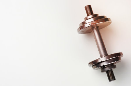 metal dumbbell with typesetting circles on a white background, sports equipment, copy spaceの写真素材