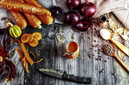 Fresh vegetables and spices on a gray wooden surface, the process of cooking fresh home made carrot juiceの写真素材