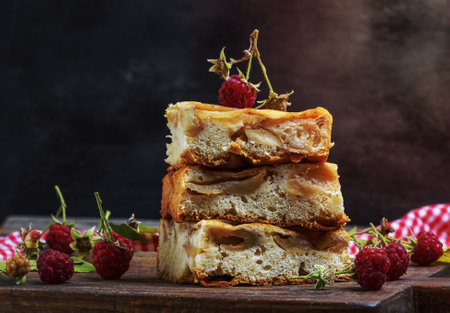 pieces of apple pie are stacked on a brown wooden board, sponge cakeの写真素材