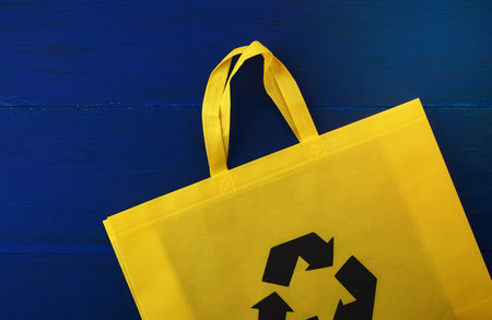 Reusable yellow viscose bag on blue wooden background, plastic waste reduction conceptの写真素材
