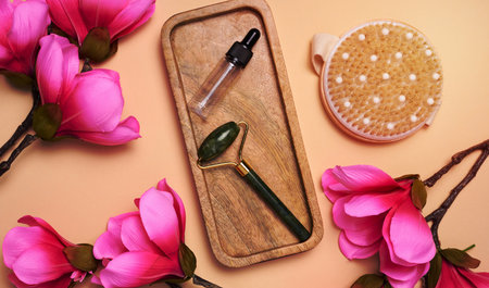 Glass bottle with a pipette and a stone massager on a beige background, items for cosmetic proceduresの写真素材