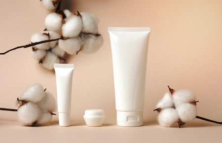 jar and empty white plastic tubes for cosmetics on a green background. Packaging for cream, gel, serum, advertising and product promotion, mock upの写真素材