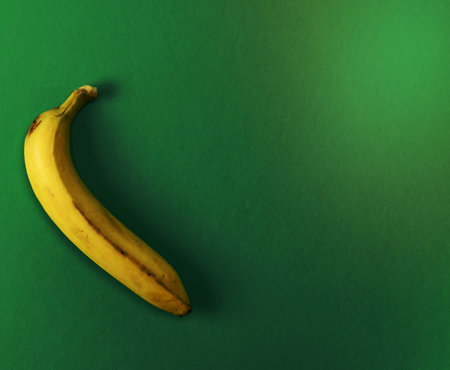 ripe yellow one banana on a green background, copy spaceの写真素材