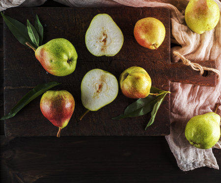ripe green pears on a brown wooden board, top viewの写真素材