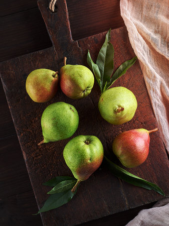 ripe green pears on a brown wooden board, top viewの写真素材