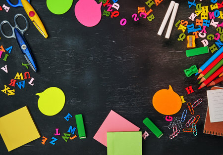 school supplies: multicolored wooden pencils, notebook, paper stickers, paper clips, pencil sharpener and white chalk, copy spaceの写真素材
