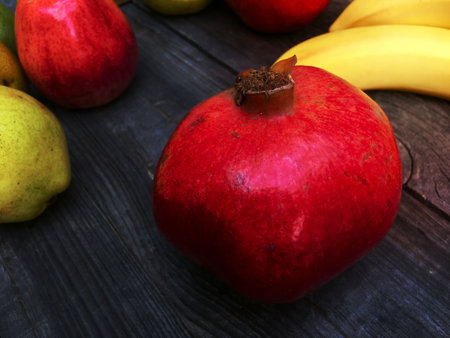 Red ripe pomegranate on a black wooden background, close-upの写真素材