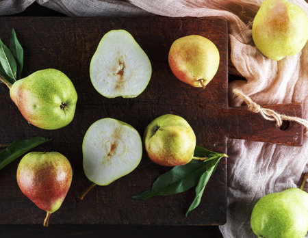 ripe green pears on a brown wooden board, top viewの写真素材