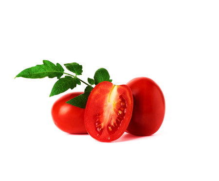 ripe red whole tomatoes and slices on a white background, autumn harvest for salad and cookingの写真素材