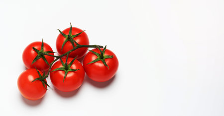 red ripe tomatoes on a green branch on white background, healthy vegetable, copy spaceの写真素材
