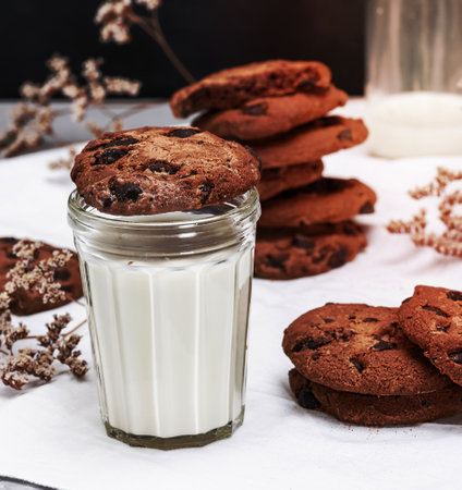 round chocolate cookie is a transparent glass with milk, breakfastの写真素材