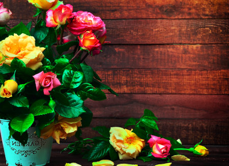 A bouquet of flowering multicolored roses in an iron bucket, empty space on the rightの写真素材