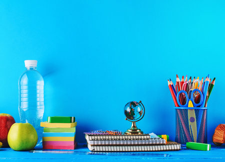 school supplies: notebook, pencils, stickers, scissors on a blue background, concept of back to schoolの写真素材
