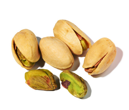 Salted open inshell pistachios isolated on a white background, tasty and healthy snack, close upの写真素材
