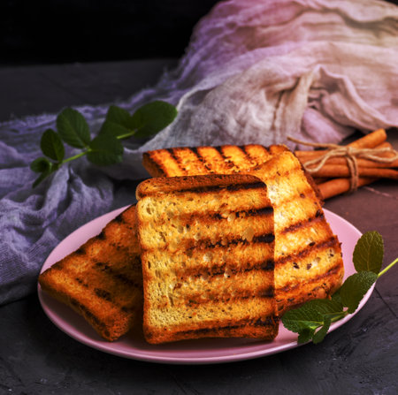 ried square pieces of white bread on a pink ceramic plate, a pile of French toastの写真素材