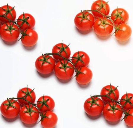 red ripe tomatoes on a green branch on white background, healthy vegetable, top viewの写真素材