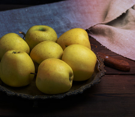 ripe fresh yellow apples on a brown wooden table, close upの写真素材