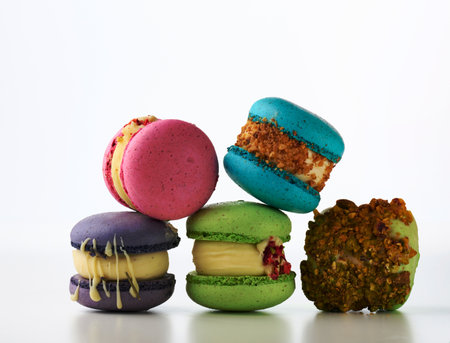 round french cakes made from almond flour macarons on a white background. Raspberry, pistachio and lavender flavorの写真素材