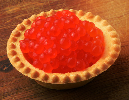 Red caviar in a round tartlet on a wooden background, delicious snackの写真素材