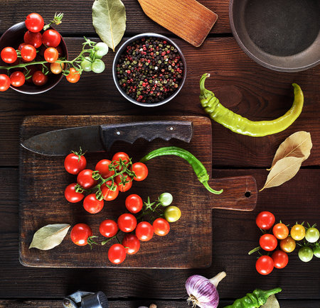 ripe red cherry tomatoes on a brown wooden table, top view, close upの写真素材
